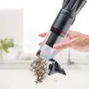 A person is emptying dust from a handheld vacuum cleaner. Produktbild-Vorschau