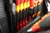 A close-up view of a tool bag interior, showing several screwdrivers and a clear-handled tool. Podgląd zdjęcia produktu