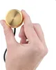A hand holding a small, round, gold-colored device with a black wire attached. Produktbild-Vorschau