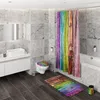 A modern bathroom with a toilet, sink, and bathtub, decorated with rainbow-themed accessories. Produktbild-Vorschau
