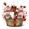 A gift basket filled with bath and body products, decorated with strawberries and splashes of pink liquid. Podgląd zdjęcia produktu
