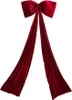 A large, red velvet bow with long streamers, isolated on a white background. Náhľad obrázku produktu