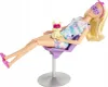 A Barbie doll is sitting in a purple chair with a small yellow cat on her lap. Both the doll and the cat are wearing pink eye masks. The doll is wearing a tie-dye dress and pink slippers. Náhľad obrázku produktu