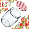 A glass jar and its lid are surrounded by various fresh vegetables and herbs, with a stylized letter 'K' logo in the upper left corner. Produktbild-Vorschau