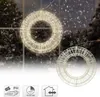 Two illuminated Christmas wreaths hanging in a window with a snowy outdoor scene in the background. Podgląd zdjęcia produktu