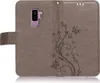 A gray flip case for a Samsung Galaxy S9 Plus with a floral and butterfly embossed design. Produktbild-Vorschau