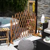 An outdoor patio scene with a hot tub, a wooden lattice screen, furniture, and plants. Podgląd zdjęcia produktu