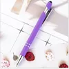 A purple pen with silver accents is laid diagonally on a white surface with a grid pattern. Several dried flowers are scattered around the pen. Produktbild-Vorschau
