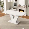 A white dining table with a V-shaped base is shown in a well-lit room with a fireplace in the background. Anteprima dell’immagine prodotto