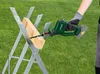 A person is using a cordless reciprocating saw to cut a piece of wood that is held in a sawhorse. Produktbild-Vorschau