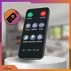 A remote control for an air purifier is displayed on a white pedestal, with a blurred background of a room. Podgląd zdjęcia produktu