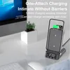 A wireless charging stand with a phone on it, placed on a desk next to a computer monitor and a small plant. Produktbild-Vorschau