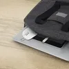 A white computer mouse and a charging cable are placed on top of a laptop, partially covered by a gray fabric bag. Produktbild-Vorschau