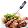 A digital food thermometer is inserted into cooked chicken wings on a white plate, with a small bowl of dipping sauce and greens in the background. Podgląd zdjęcia produktu