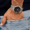 A person's hand wearing a watch is placed in the pocket of their jeans. Podgląd zdjęcia produktu