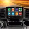 A car's dashboard with a large infotainment screen displaying various app icons, with a road scene in the background. Podgląd zdjęcia produktu