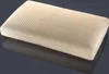 A beige pillow with many small holes is shown on a reflective dark gray surface. Produktbild-Vorschau