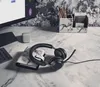A desk setup with a headset, notebook, and computer monitor. Produktbild-Vorschau