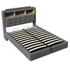 A grey upholstered bed frame with a slatted base and a headboard with built-in shelves. Produktbild-Vorschau