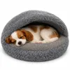 A small dog sleeping in a round, hooded pet bed. Produktbild-Vorschau