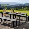 An outdoor dining set with benches and a table is set up on a wooden deck, with a scenic view of rolling hills and mountains in the background. Produktbild-Vorschau