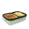 A light green electric hot pot with a black divided cooking surface, filled with food, isolated on a white background. Produktbild-Vorschau