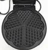 A top-down view of an open black heart-shaped waffle iron with its cooking plates visible. Náhled obrázku produktu