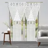 A pair of white striped curtains with decorative silver bands and a white vase with flowers on a small wooden table. Náhľad obrázku produktu