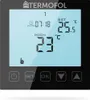 A digital thermostat display showing current room temperature, set temperature, and time, with control buttons at the bottom. Produktbild-Vorschau