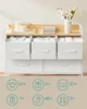 A white dresser with fabric drawers, displaying clothing items and decorative elements on top. Náhled obrázku produktu