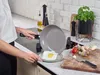 A person is cooking an egg in a pan in a kitchen. Produktbild-Vorschau