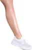 A close-up shot of a woman's lower leg and foot wearing a white sneaker.