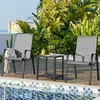 Two chairs and a small table are set up on a wooden deck next to a swimming pool, surrounded by lush greenery. Produktbild-Vorschau