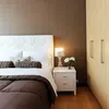 A bedroom scene with a bed, nightstand, and wardrobe. Náhled obrázku produktu