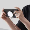 A person holding a smartphone with a case and a magnetic charger attached. Produktbild-Vorschau