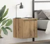A bedside table next to a bed with a lamp and a plant. Náhled obrázku produktu