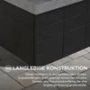 A close-up of a black outdoor fireplace with a stone countertop, set on a paved patio. Text overlays describe its construction. Náhled obrázku produktu