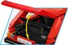 A close-up view of the open trunk of a red Lego Volkswagen Golf model, with yellow arrows indicating movement. Náhled obrázku produktu