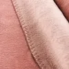 A close-up view of a pink blanket, showing the texture and stitching. Produktbild-Vorschau