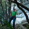 Ein Kletterer trainiert an einem Rocky Trainingboard von YY Vertical; umgeben von Felsen und Bäumen. Podgląd zdjęcia produktu