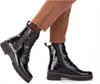 A pair of women's blue patent leather lace-up boots with a side zipper, worn with brown pants. Produktbild-Vorschau