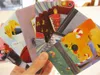 A hand holding several colorful cards with illustrations. Náhled obrázku produktu