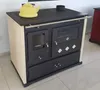 A freestanding wood-burning stove with a cream-colored body and black front, featuring a yellow kettle on top. Produktbild-Vorschau
