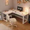 A white L-shaped computer desk with a white office chair in front of it, set in a room with wooden floors and gray walls. Produktbild-Vorschau