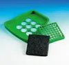 A green plastic waste bin accessory set, including a tray with circular openings, a perforated grid, and a black filter pad, is displayed against a gradient background. Produktbild-Vorschau