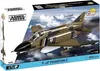 The image shows the packaging of a COBI F-4F Phantom II™ model airplane kit, with the model airplane prominently displayed in flight against a cloudy sky. Produktbild-Vorschau