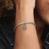A close-up shot of a person's arm wearing a silver bracelet with a Hamsa hand charm. Anteprima dell’immagine prodotto