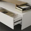 A close-up view of an open drawer in a white piece of furniture, showing books and glasses inside. A wooden shelf is visible above. Náhled obrázku produktu