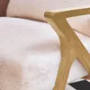 A close-up view of a white faux fur armchair with a gold-colored armrest. Produktbild-Vorschau