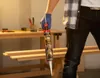 A person in a workshop setting holds a tube of glue. Podgląd zdjęcia produktu